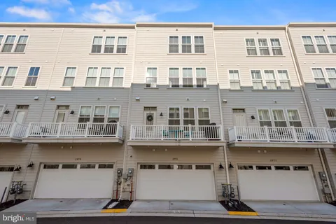 a balcony with stainless steel appliances kitchen island granite countertop a sink a stove and a wooden floors