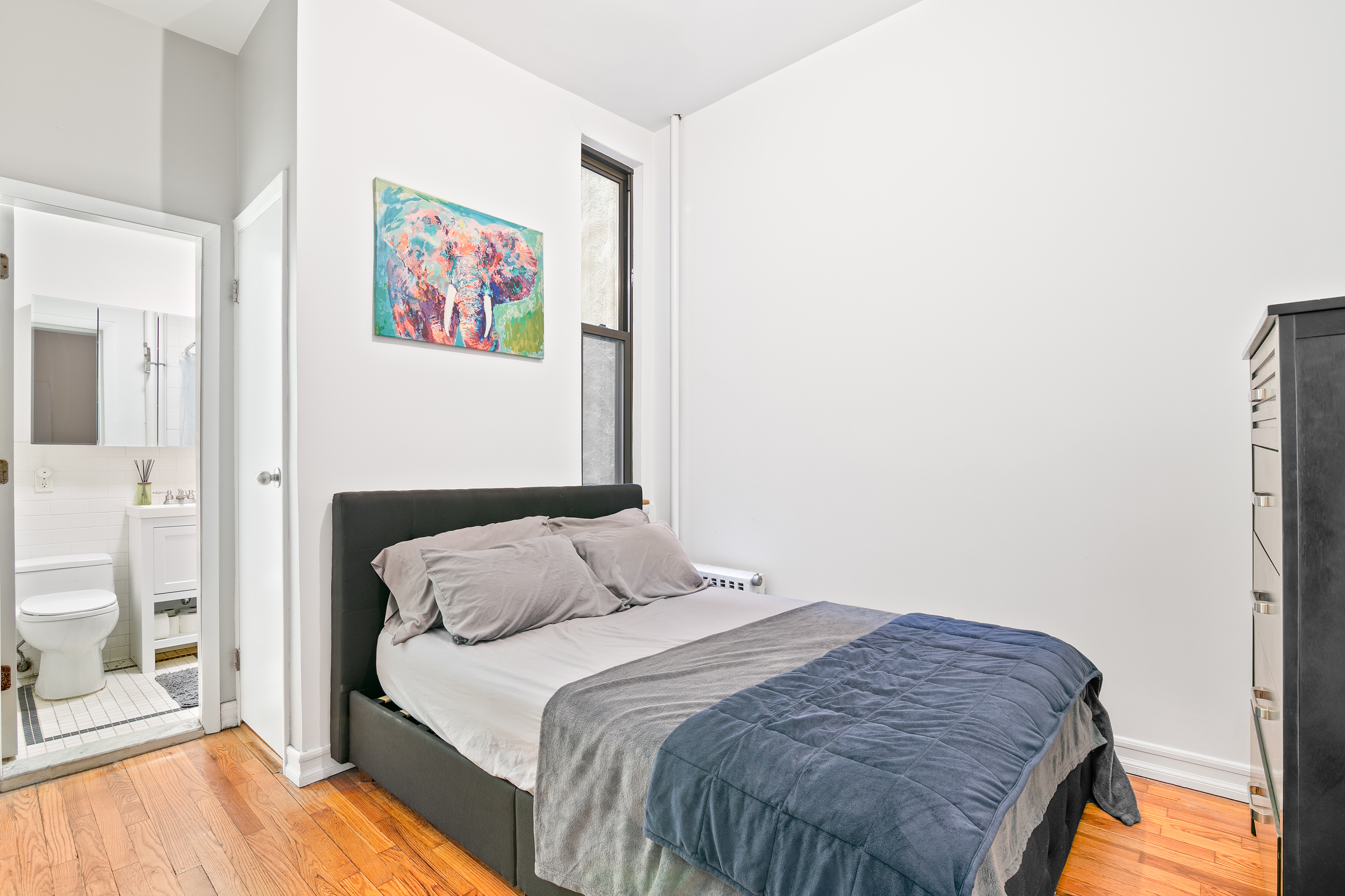 237 East 88th Street, Unit 401 Manhattan, NY 10128 - Photo 3 of 7 a bedroom with a bed and wooden floor