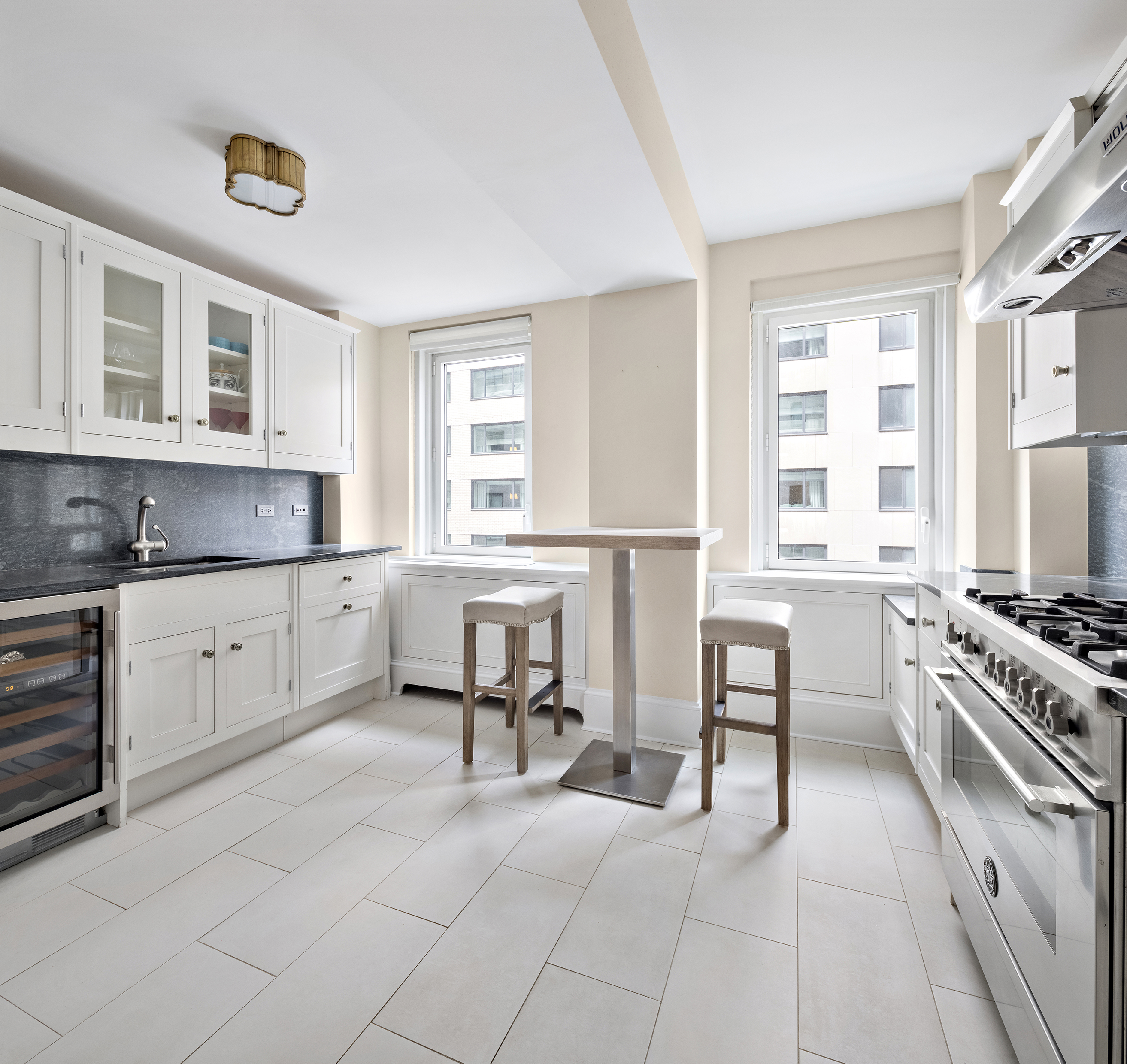 530 Park Avenue, Unit 10D Manhattan, NY 10065 - Photo 6 of 13 a kitchen with stainless steel appliances a stove a sink and white cabinets with wooden floor