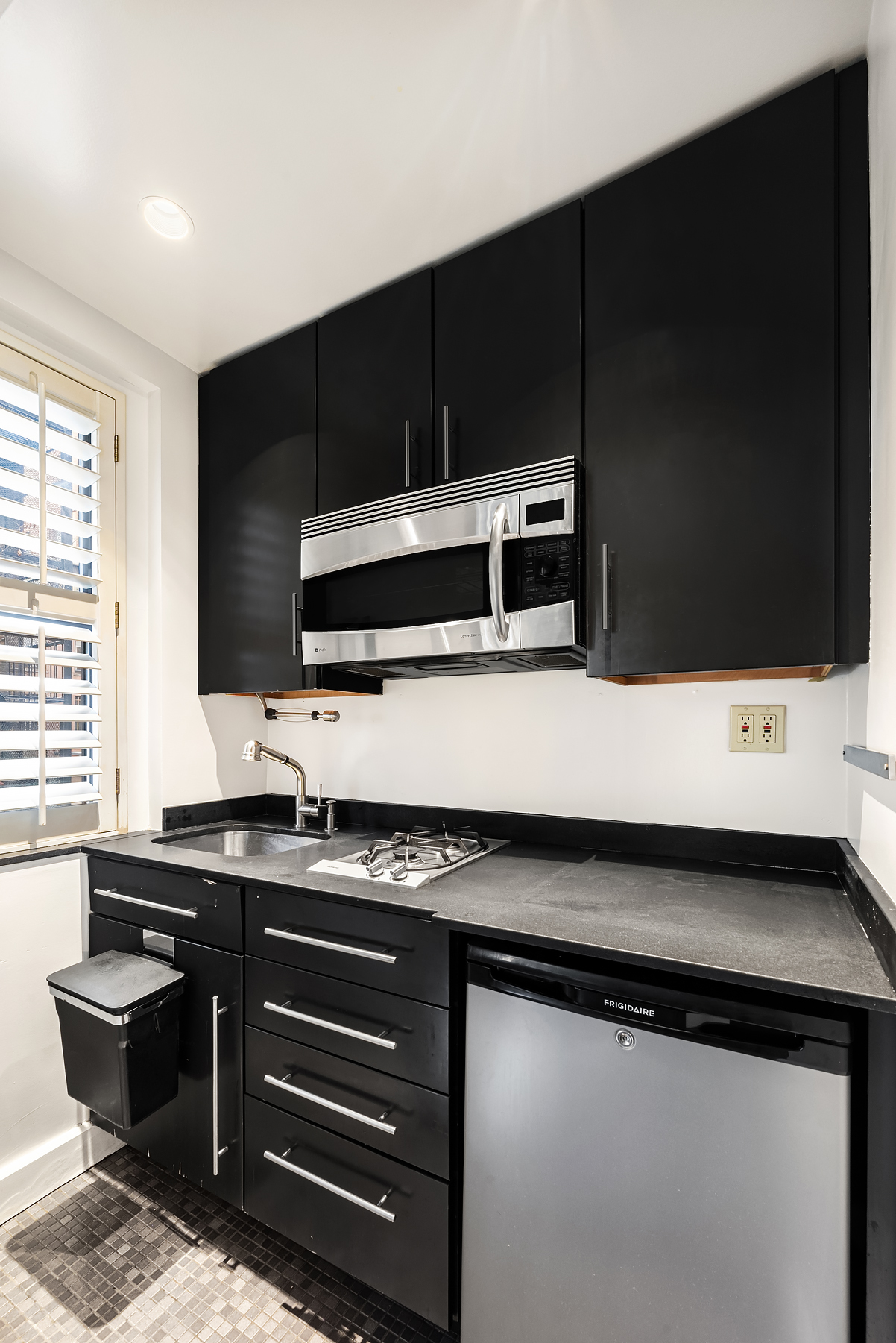 339 East 58th Street, Unit 3J Manhattan, NY 10022 - Photo 4 of 9 a kitchen with a sink and a microwave