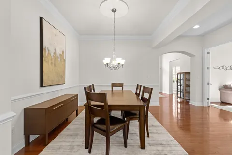 a view of a dining room with furniture wooden floor and chandelier