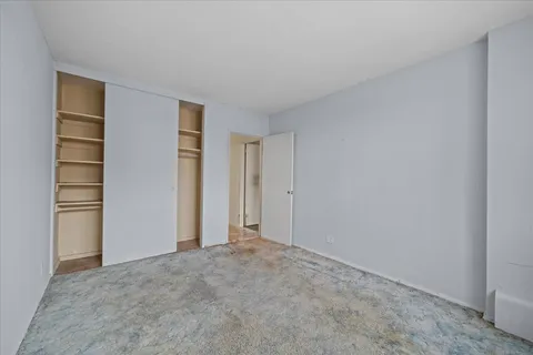 a view of an empty room and kitchen space