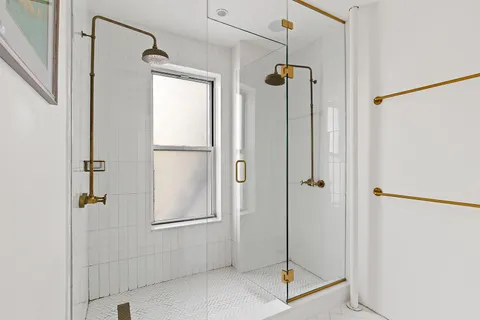 a bathroom with a shower and a glass door