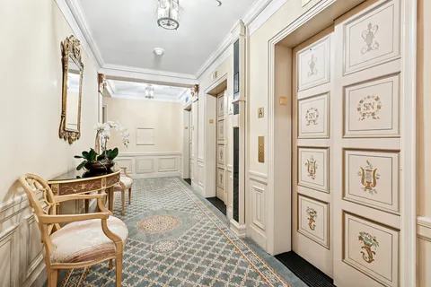 a view of a hallway with a dining table and chairs
