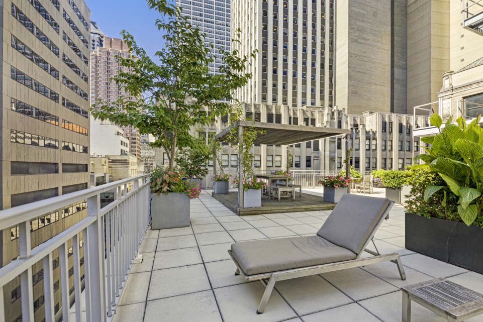 59 John Street, Unit 4H Manhattan, NY 10038 - Photo 16 of 19 a view of a patio with a table and chairs and potted plants