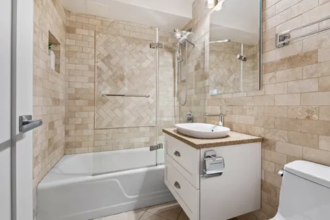 a bathroom with a sink a toilet and shower