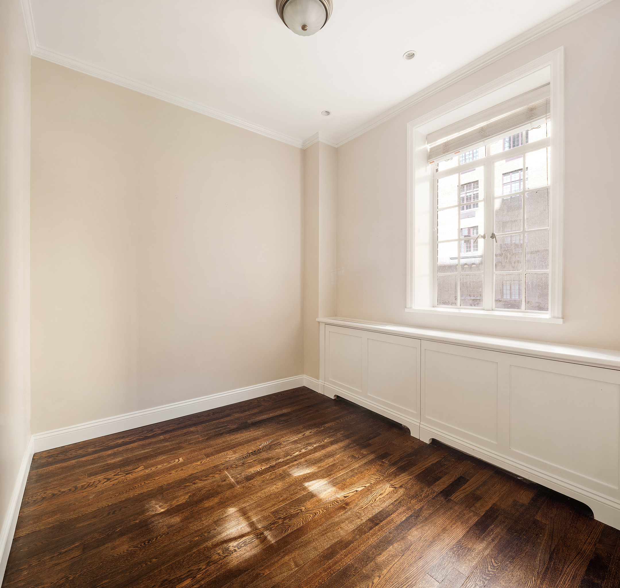 115 East 67th Street, Unit 3C Manhattan, NY 10065 - Photo 15 of 21 a view of an empty room with wooden floor and a window