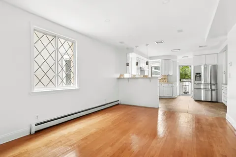 a view of a kitchen with wooden floor and a window
