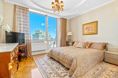 a bedroom with a bed and a chandelier