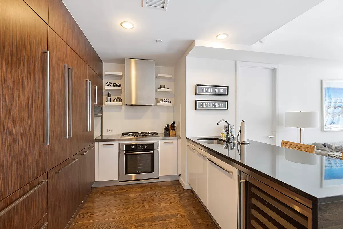 133 West 22nd Street, Unit 12B Manhattan, NY 10011 - Photo 3 of 12 a kitchen with stainless steel appliances granite countertop a sink stove and refrigerator