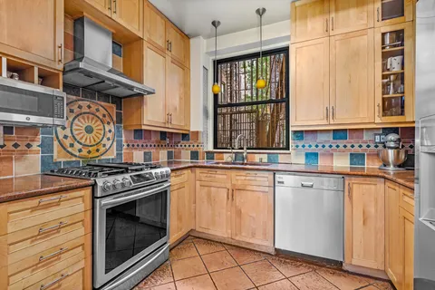 a kitchen with stainless steel appliances granite countertop a stove and a sink