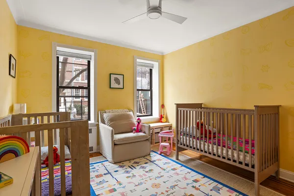 a living room with furniture and baby crib