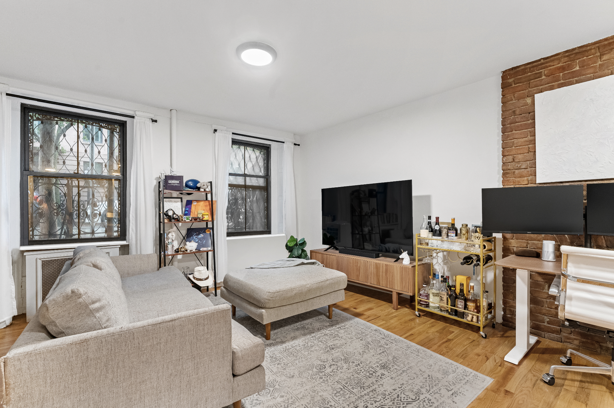 355 West 20th Street, Unit 1 Manhattan, NY 10011 - Photo 2 of 9 a living room with furniture and a flat screen tv