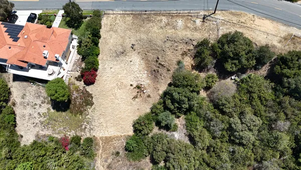 an aerial view of a house with a yard and garden