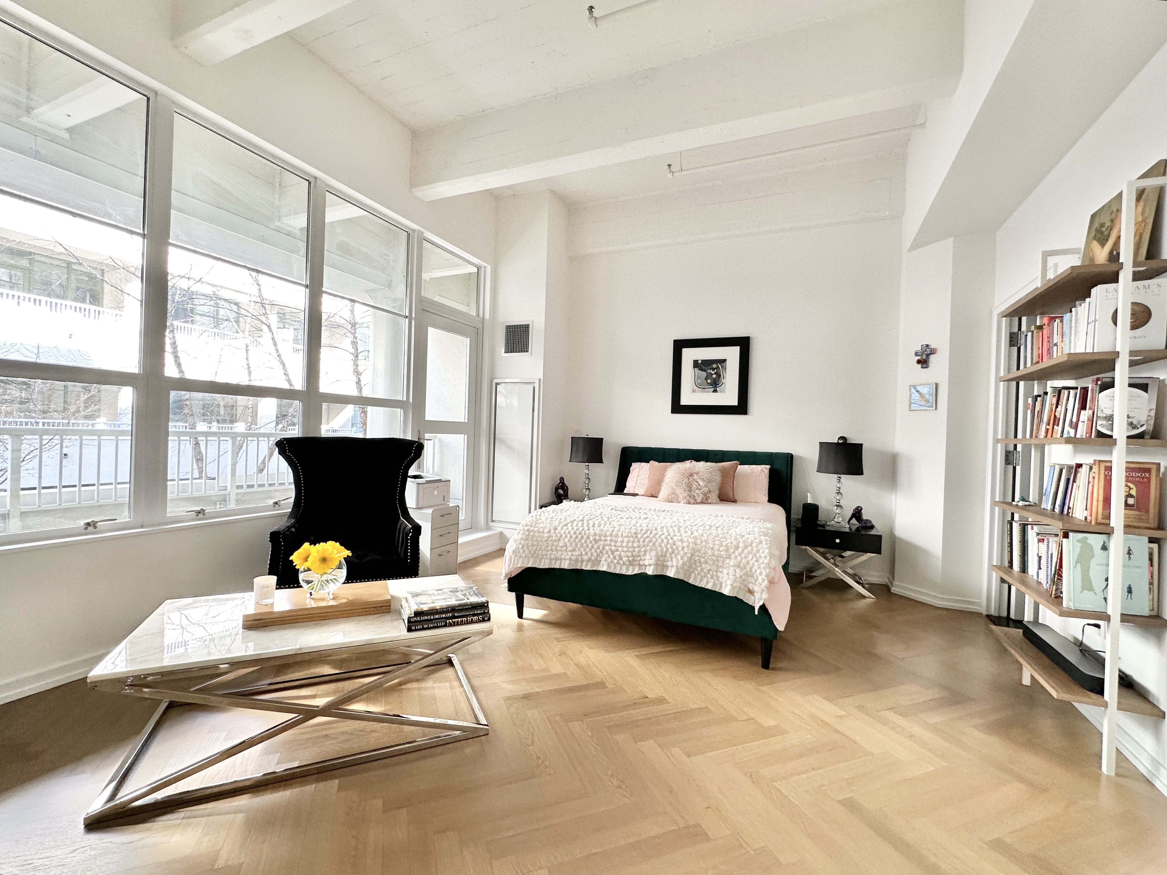 a bedroom with a bed and large windows