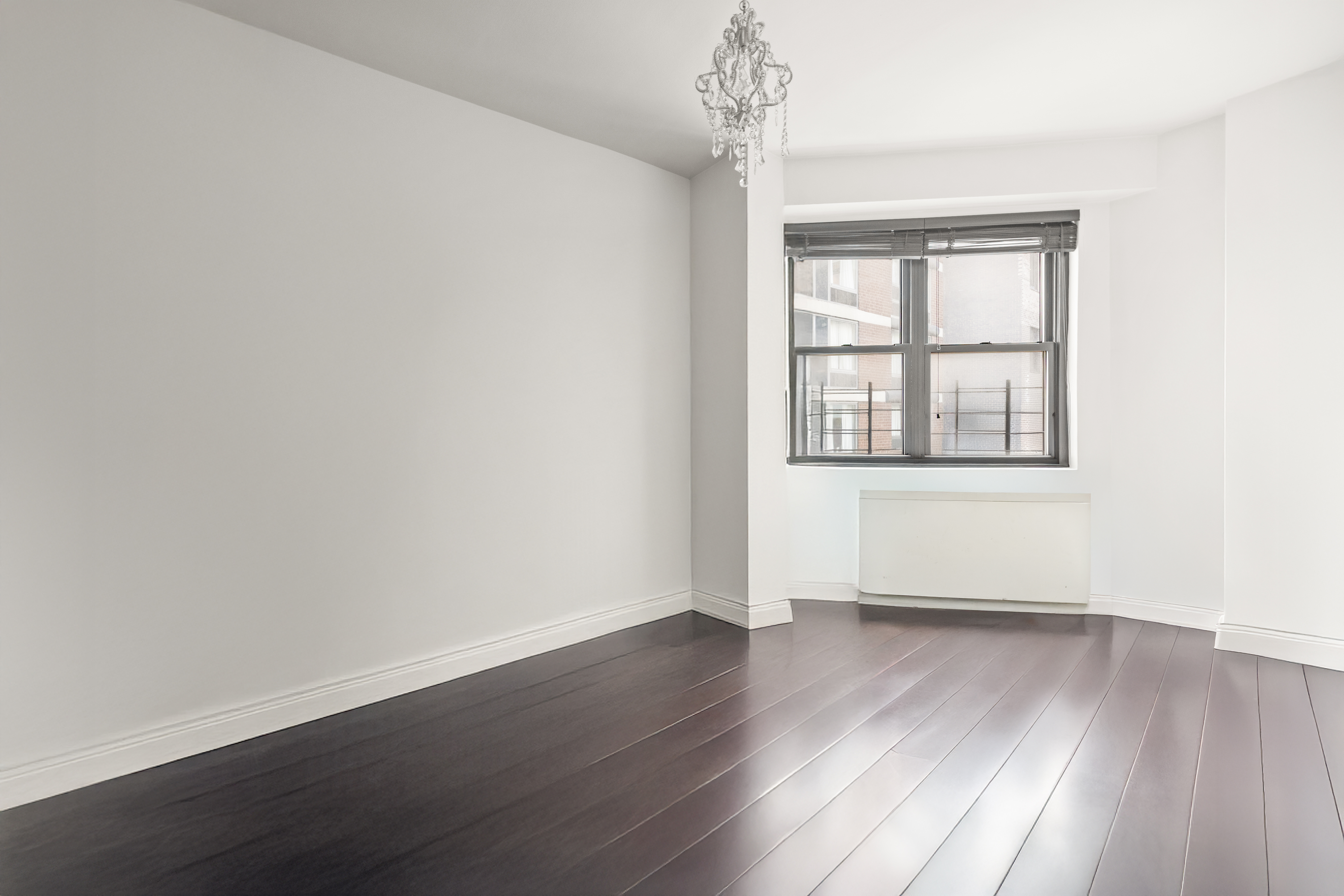 136 East 56th Street, Unit 10JK Manhattan, NY 10022 - Photo 7 of 12 an empty room with wooden floor and windows