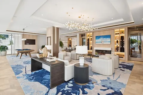 a living room with furniture a chandelier and a dining table with wooden floor