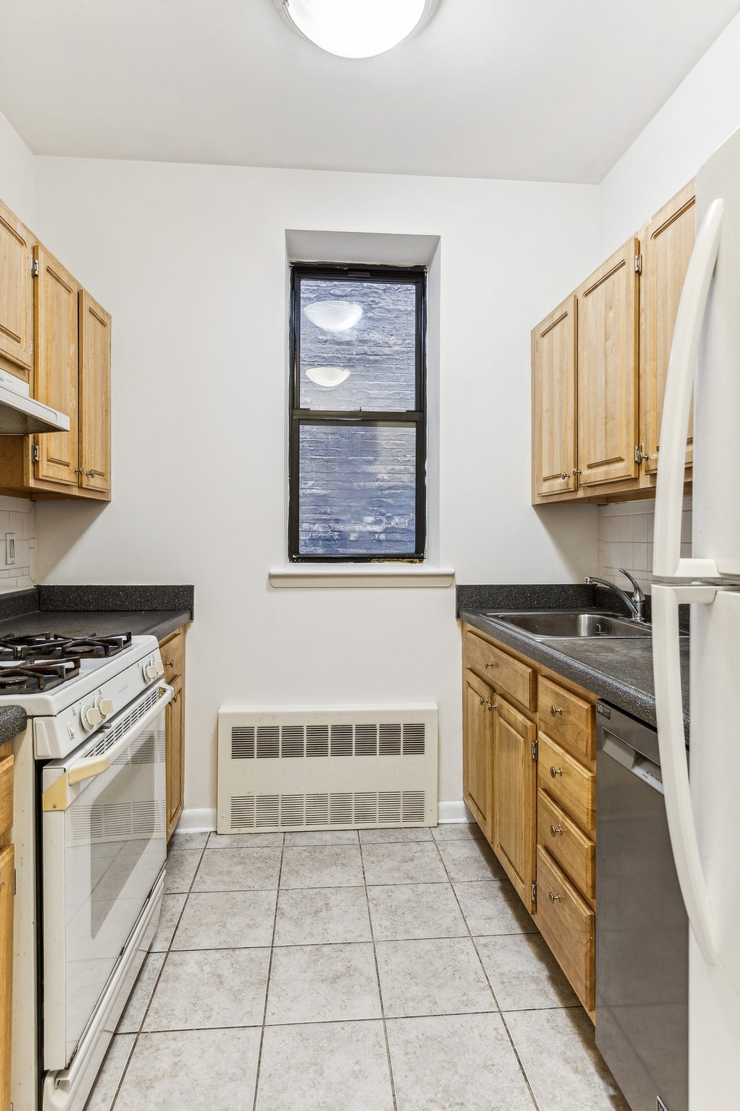 307 West 111th Street, Unit 2R Manhattan, NY 10026 - Photo 2 of 16 a kitchen with stainless steel appliances granite countertop a stove a sink and a microwave