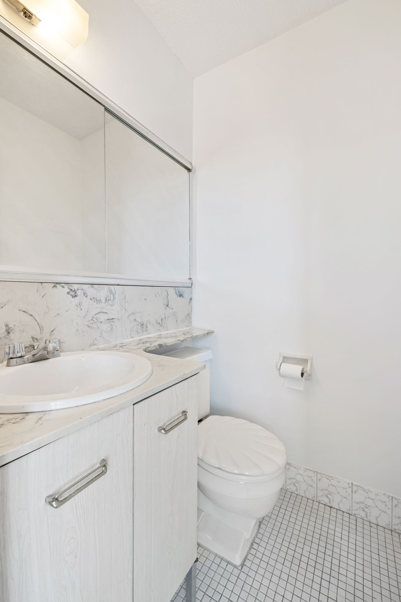 201 East 17th Street, Unit 15H Manhattan, NY 10003 - Photo 9 of 24 a bathroom with a sink a toilet and vanity
