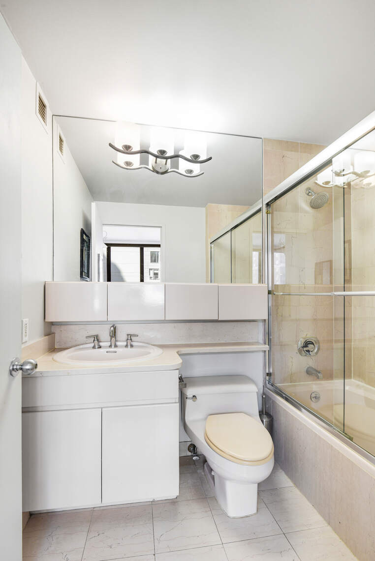 455 East 86th Street, Unit 8D Manhattan, NY 10028 - Photo 7 of 13 a bathroom with a toilet a sink and mirror