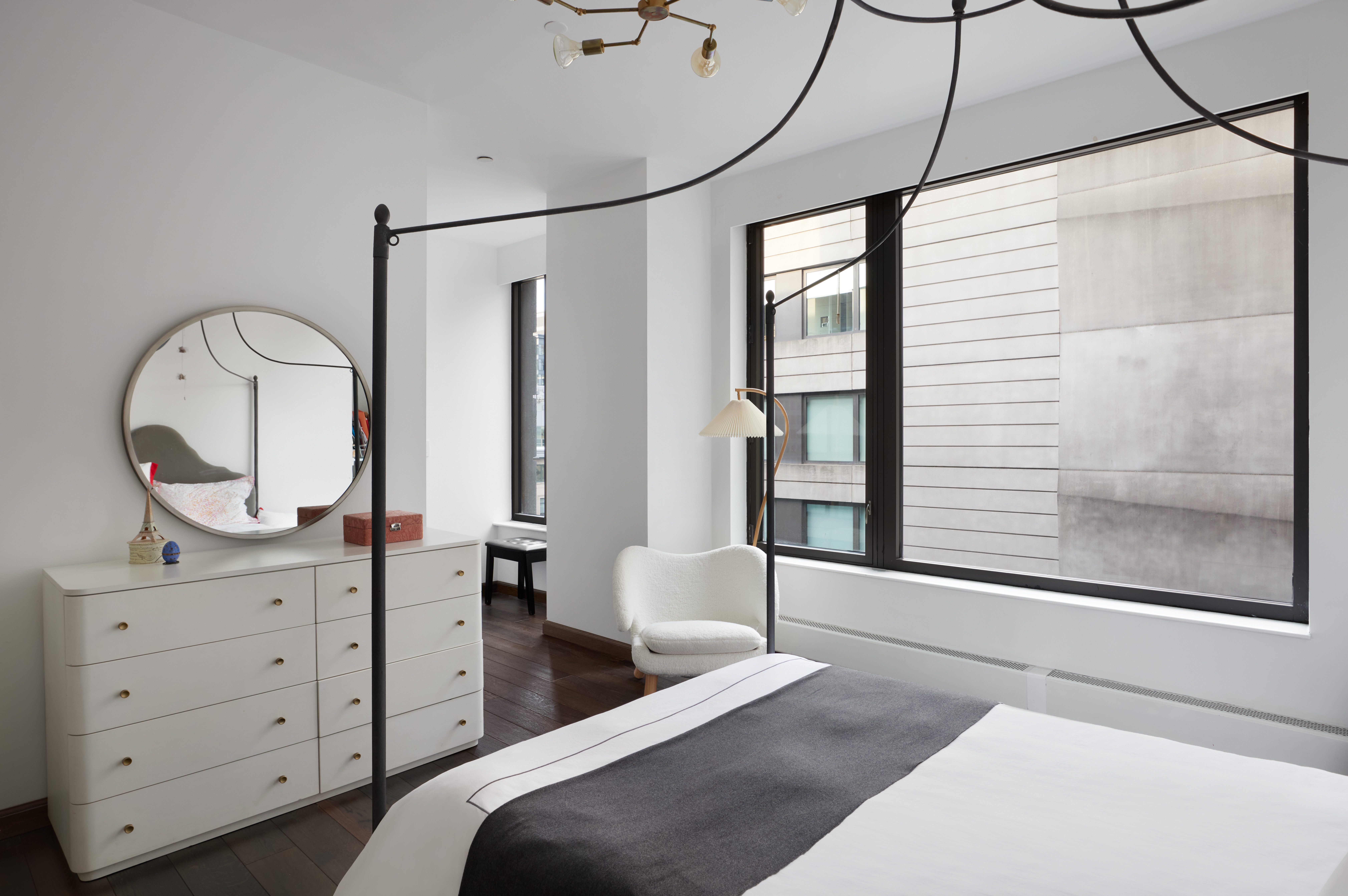 505 Greenwich Street, Unit 14A Manhattan, NY 10013 - Photo 14 of 20 a bedroom with a bed a mirror on the dresser and a chandelier