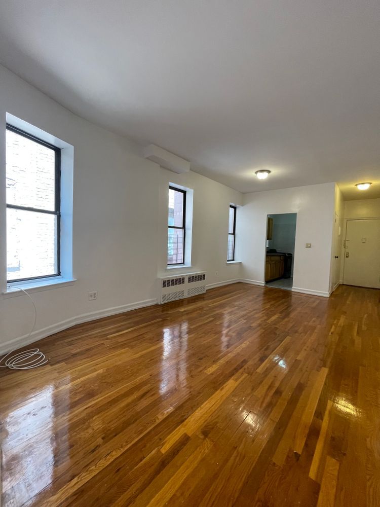 1280 Dean Street, Unit 3E Brooklyn, NY 11216 - Photo 1 of 5 a view of empty room with wooden floor and fan