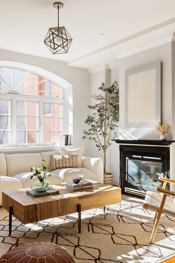 a living room with a fireplace and chandelier