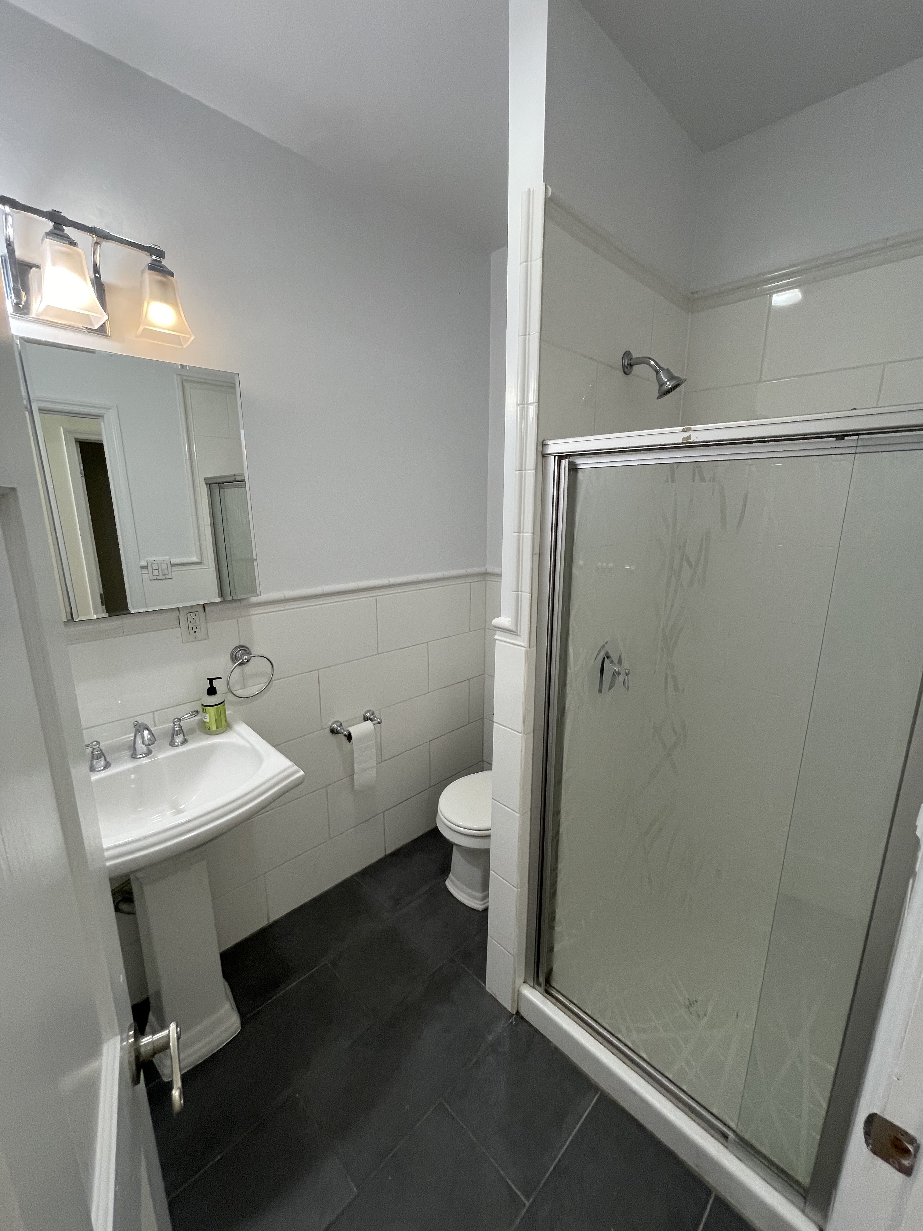 263 Adelphi Street, Unit 1 Brooklyn, NY 11205 - Photo 3 of 14 a bathroom with a granite countertop toilet a sink and a mirror