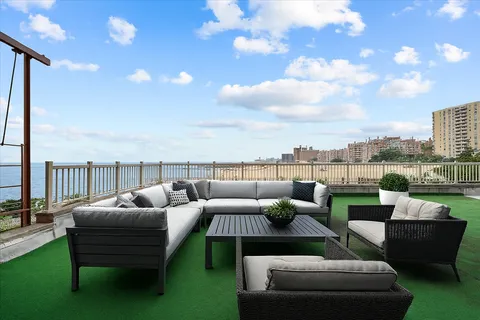 a roof deck with couches and potted plants
