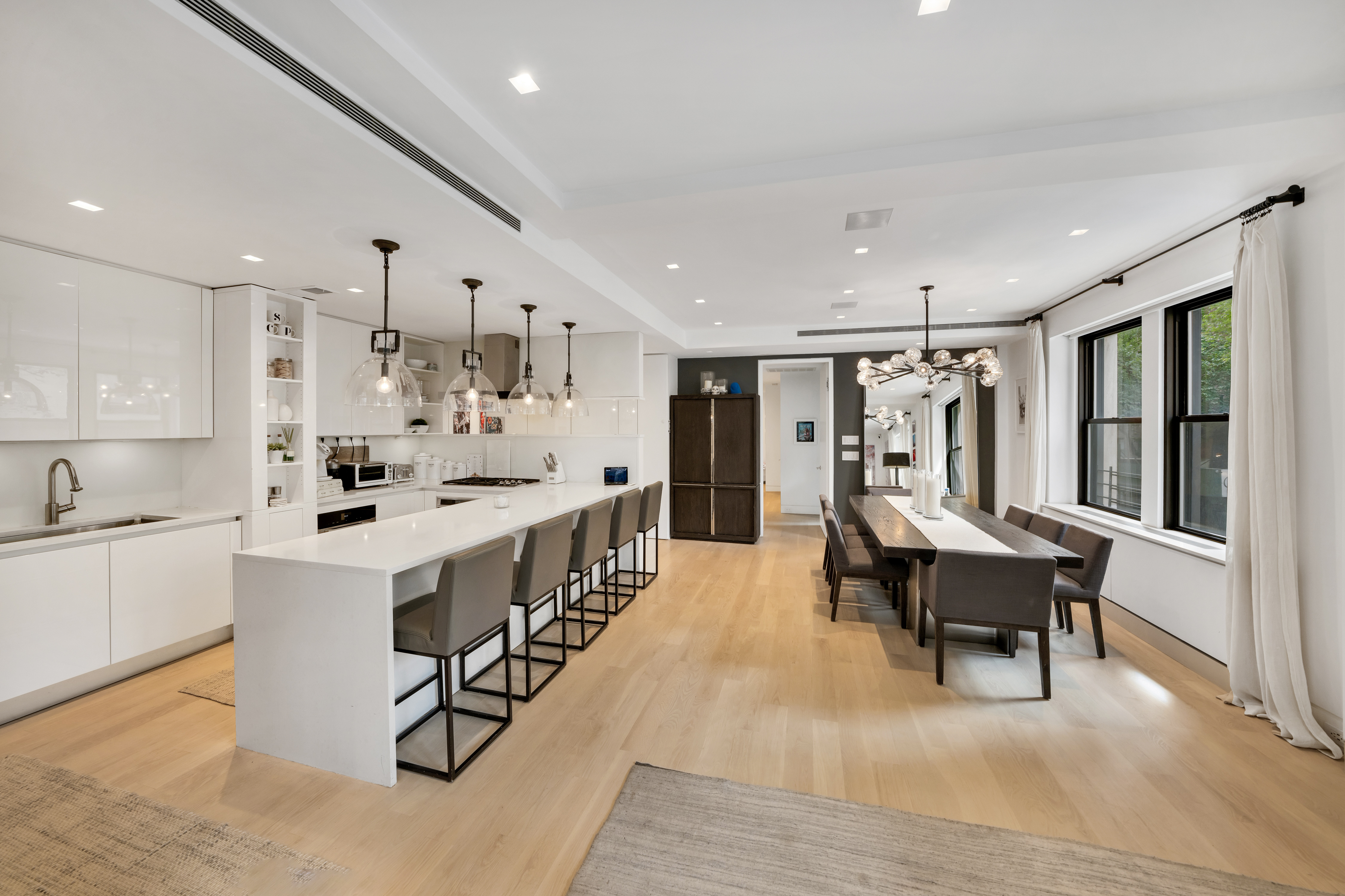 67 Park Avenue, Unit 2BC Manhattan, NY 10016 - Photo 2 of 16 a large white dining with stainless steel appliances kitchen island a table chairs a sink and a refrigerator