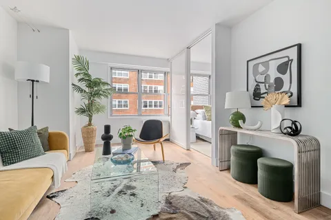 a living room with furniture a flat screen tv and a large window