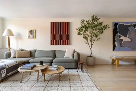 a living room with furniture a chandelier and a potted plant