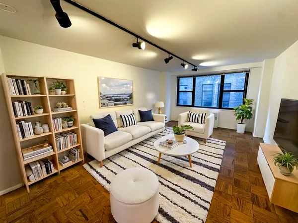 a living room with furniture a rug and a flat screen tv