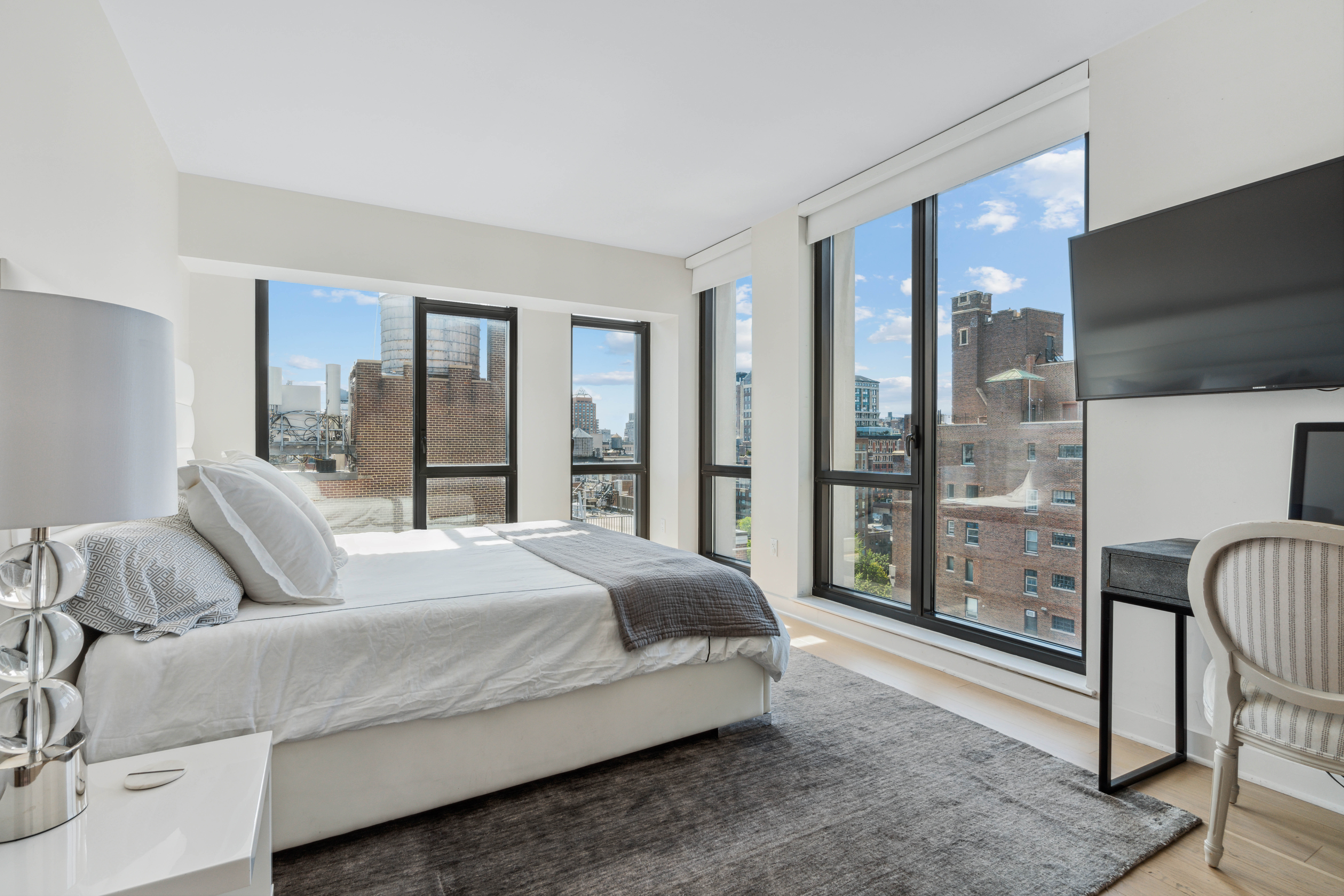 160 East 22nd Street, Unit 18C Manhattan, NY 10010 - Photo 7 of 12 a bedroom with a large bed and a balcony view