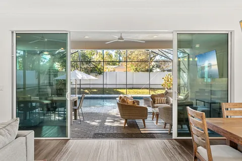 a living room with a floor to ceiling window and wooden floor