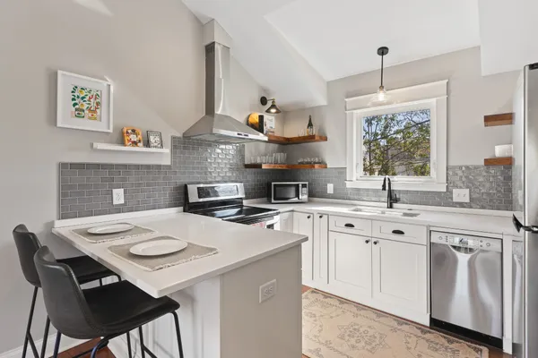 a kitchen with stainless steel appliances a table chairs and a refrigerator