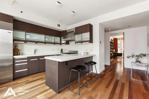 a kitchen with wooden floors and wooden cabinets