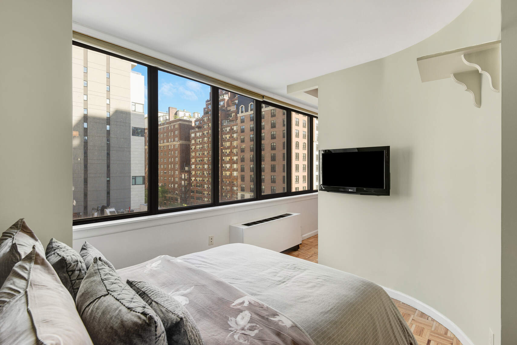 455 East 86th Street, Unit 8D Manhattan, NY 10028 - Photo 3 of 13 a bedroom with a bed and a flat tv screen next to a window