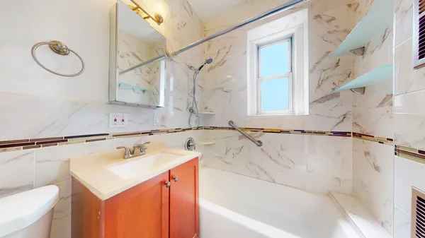 a bathroom with a sink vanity and a bathtub