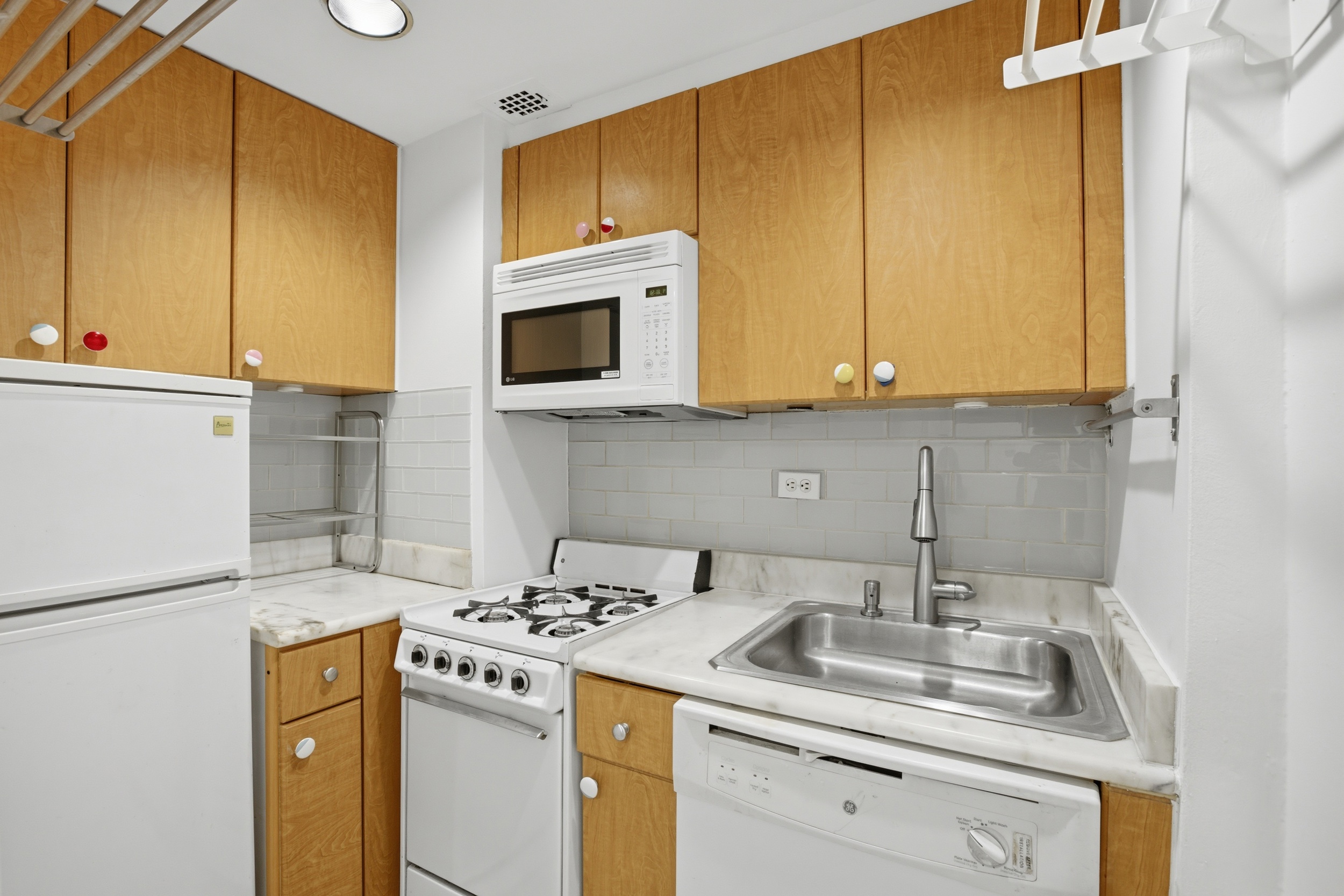 321 East 45th Street, Unit 2H Manhattan, NY 10017 - Photo 3 of 5 a kitchen with stainless steel appliances granite countertop a sink stove and refrigerator