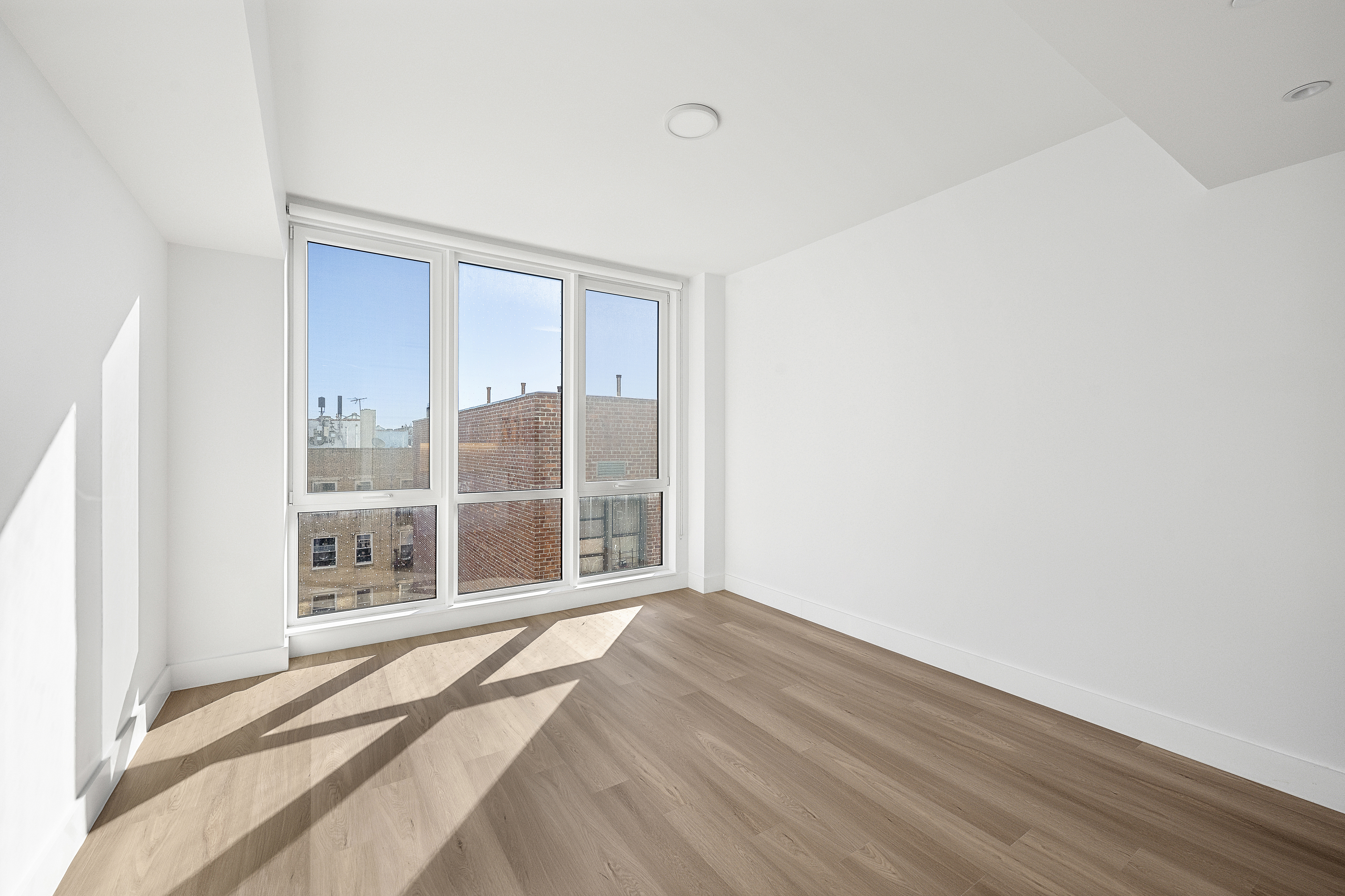 340 Lenox Road, Unit 6A Brooklyn, NY 11226 - Photo 1 of 26 a view of an empty room with wooden floor and a window