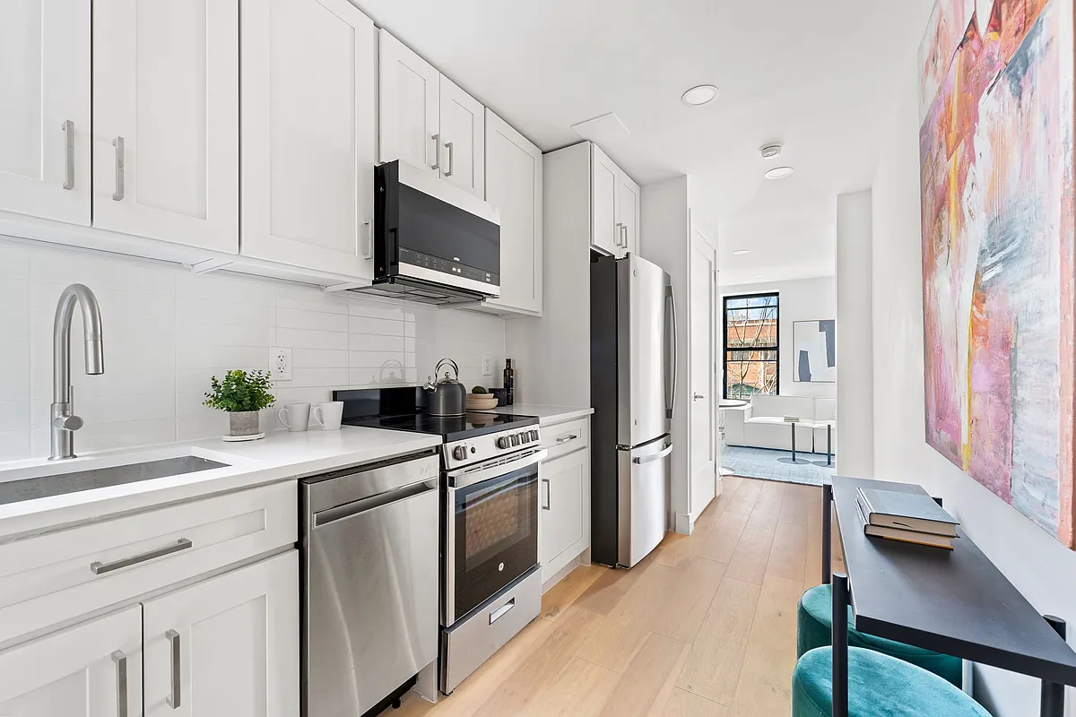 168 Sumpter Street, Unit 2 Brooklyn, NY 11233 - Photo 4 of 10 a kitchen with stainless steel appliances white cabinets and a sink