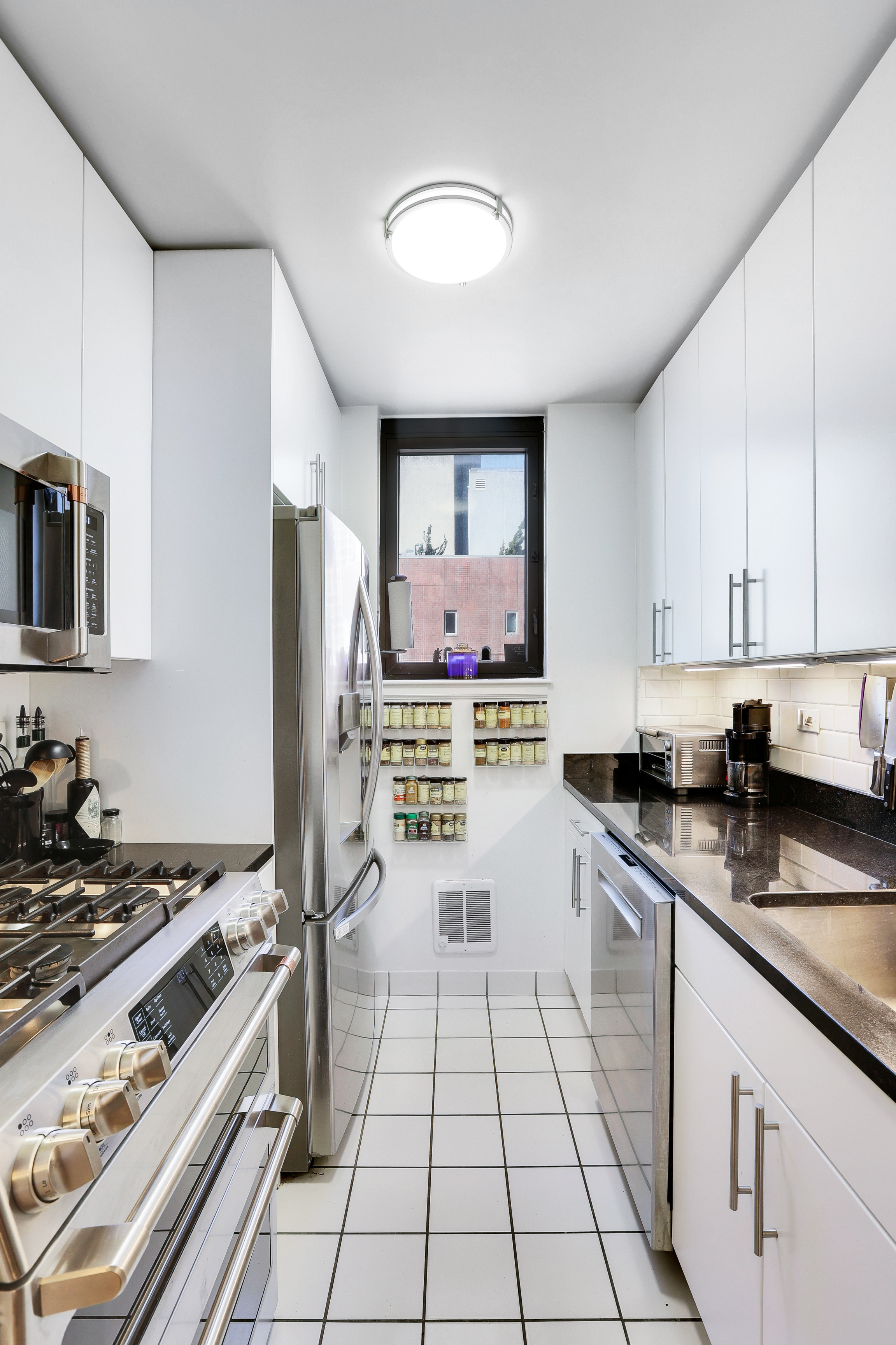 330 East 38th Street, Unit 20E Manhattan, NY 10016 - Photo 10 of 17 a kitchen with a stove a sink and a refrigerator