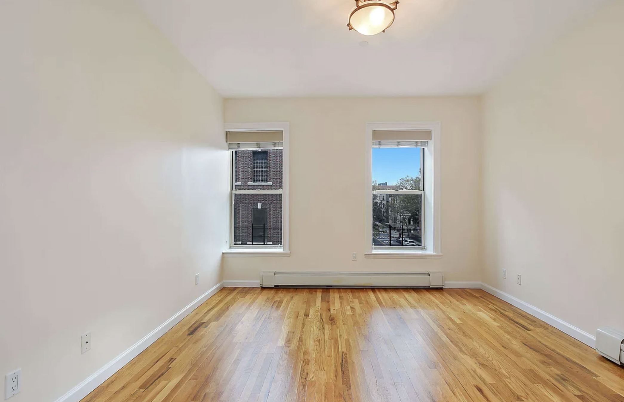 370 Convent Avenue, Unit 3B Manhattan, NY 10031 - Photo 6 of 12 an empty room with wooden floor and windows