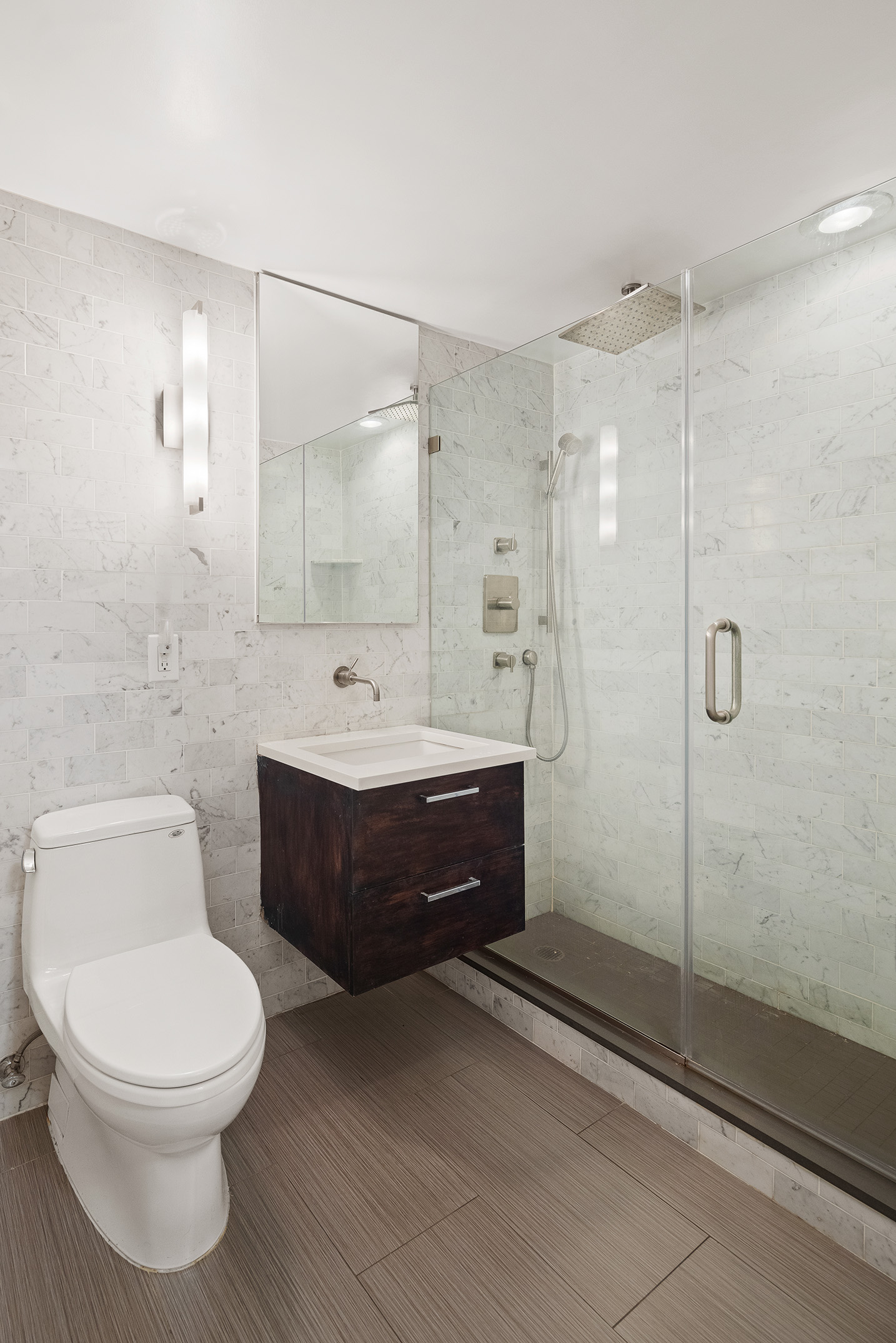 11 5th Avenue, Unit 3E Manhattan, NY 10003 - Photo 5 of 6 a bathroom with a toilet a sink a mirror and shower