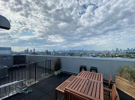 a view of a roof deck with couches and wooden floor