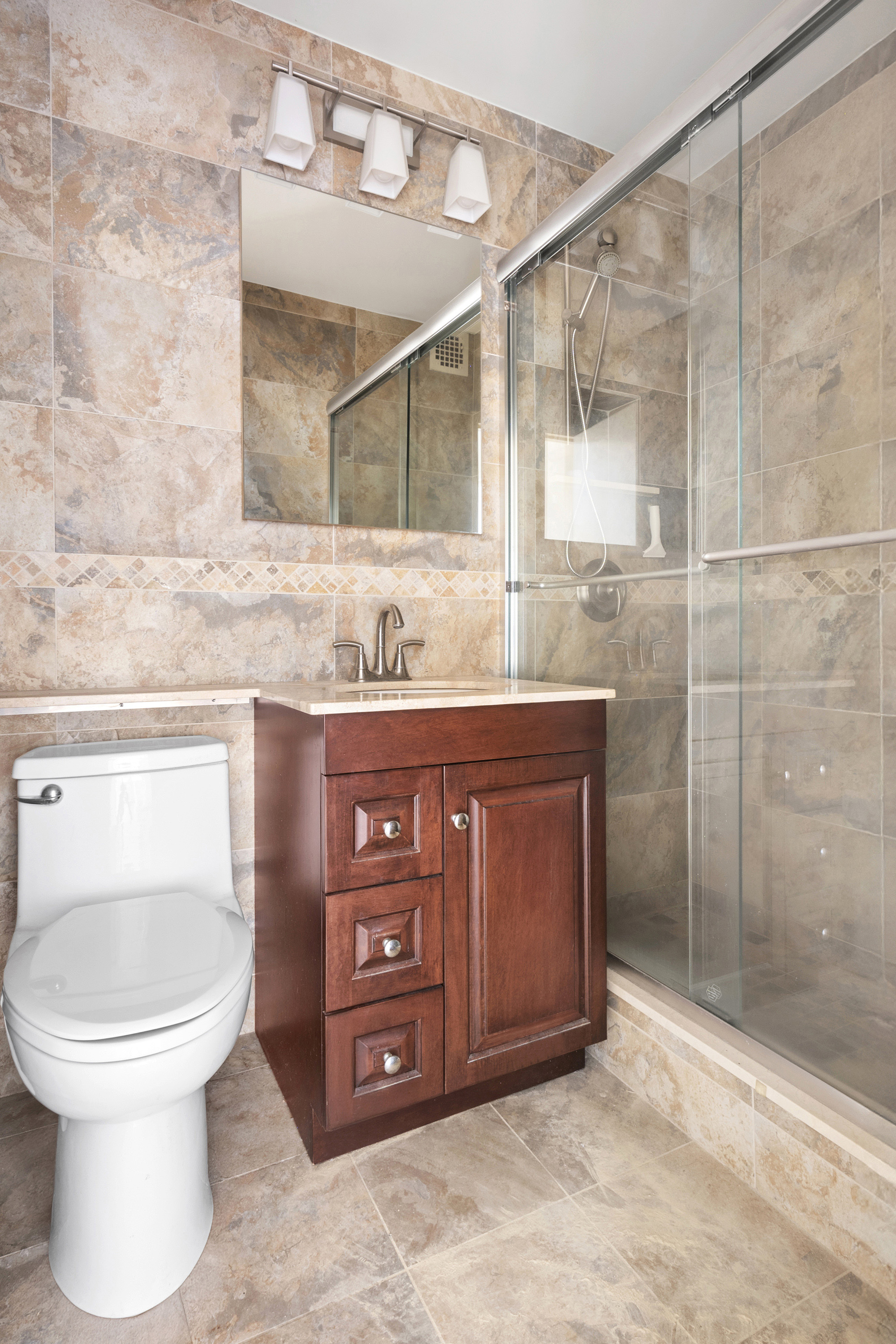 180 West End Avenue, Unit 28S Manhattan, NY 10023 - Photo 7 of 10 a bathroom with a toilet a sink and mirror