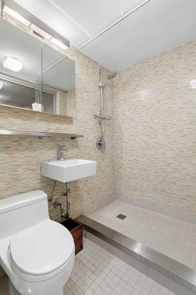 a bathroom with a sink a toilet and shower