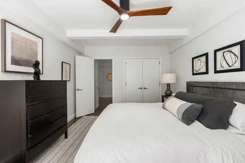 a bedroom with a bed and a painting on the wall