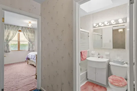 a bathroom with a sink mirror and window